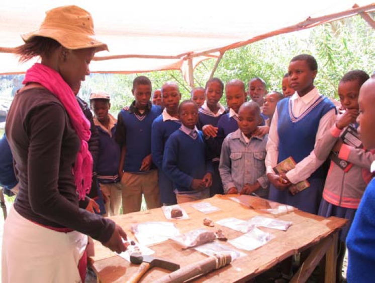 'M'e Matikoe Matsoso demonstrates how stone tools work to students from Metolong